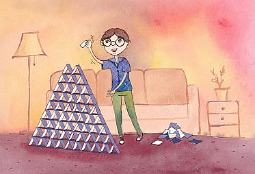 A man with glasses placing a card on top of a very large house of cards.